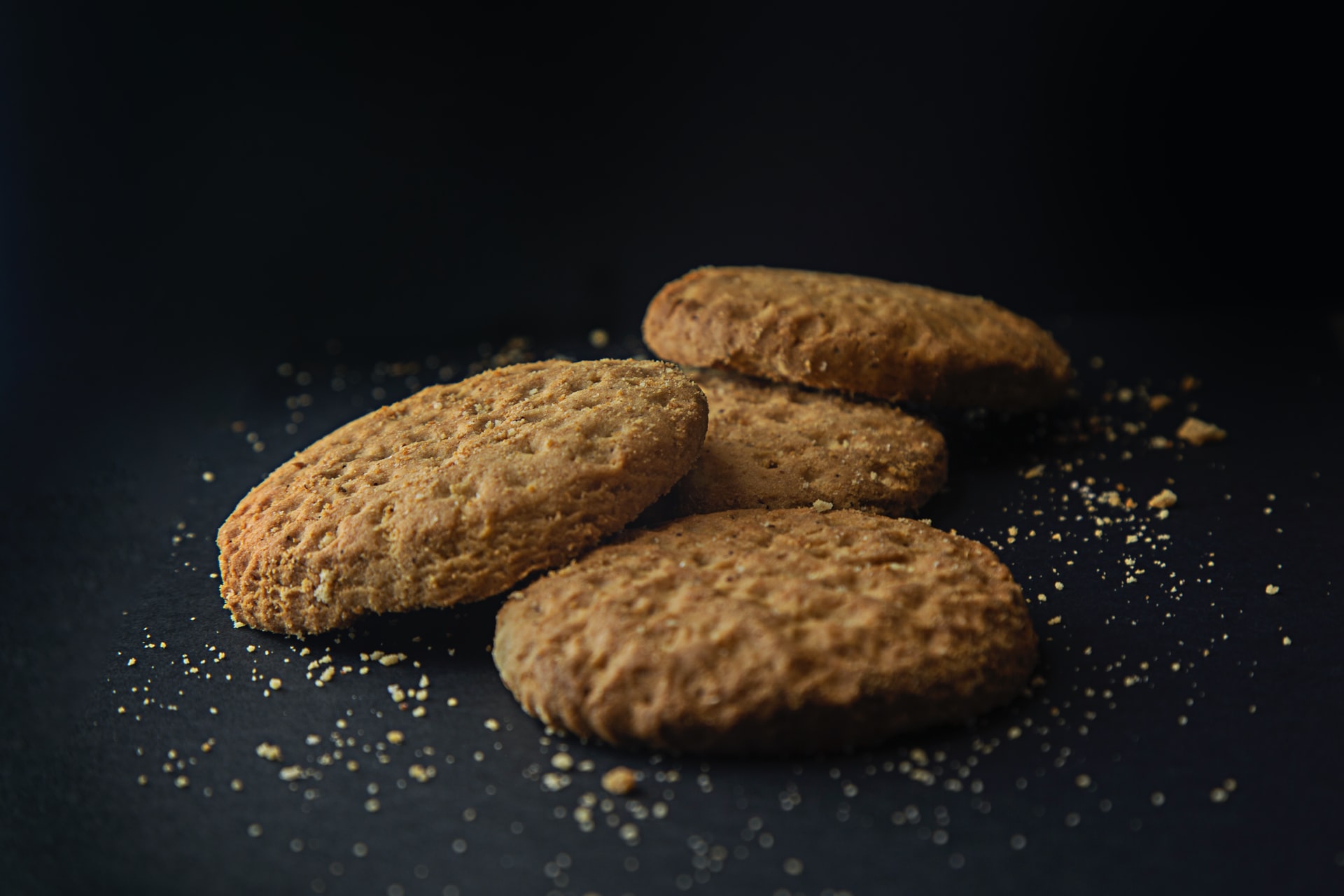 three brown cookies on black surface